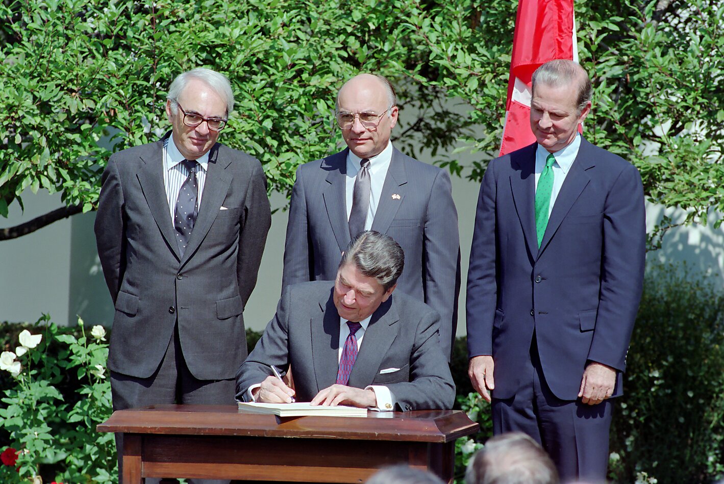 President Reagan in the Rose Garden signing the Canada United States Free Trade Agreement FTA with James Baker Clayton Yeutter and Allan Gotlieb looking on.