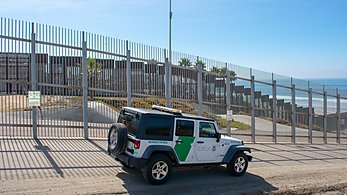 US Border Patrol jeep along the US-Mexico border fence