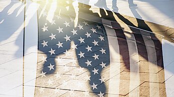 American flag with shadows of people 