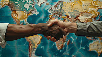 Handshake in front of world map - Annual Report 2023