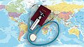 Stethoscope and passport on top of a world map