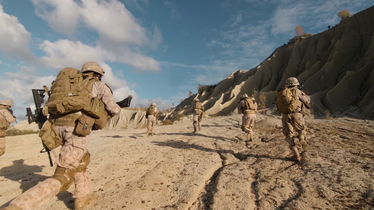 US soldiers on patrol in the desert, heading away from the camera