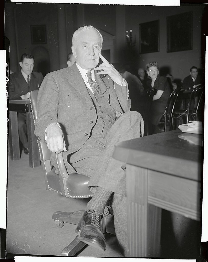 Cordell Hull sitting in a chair at a hearing