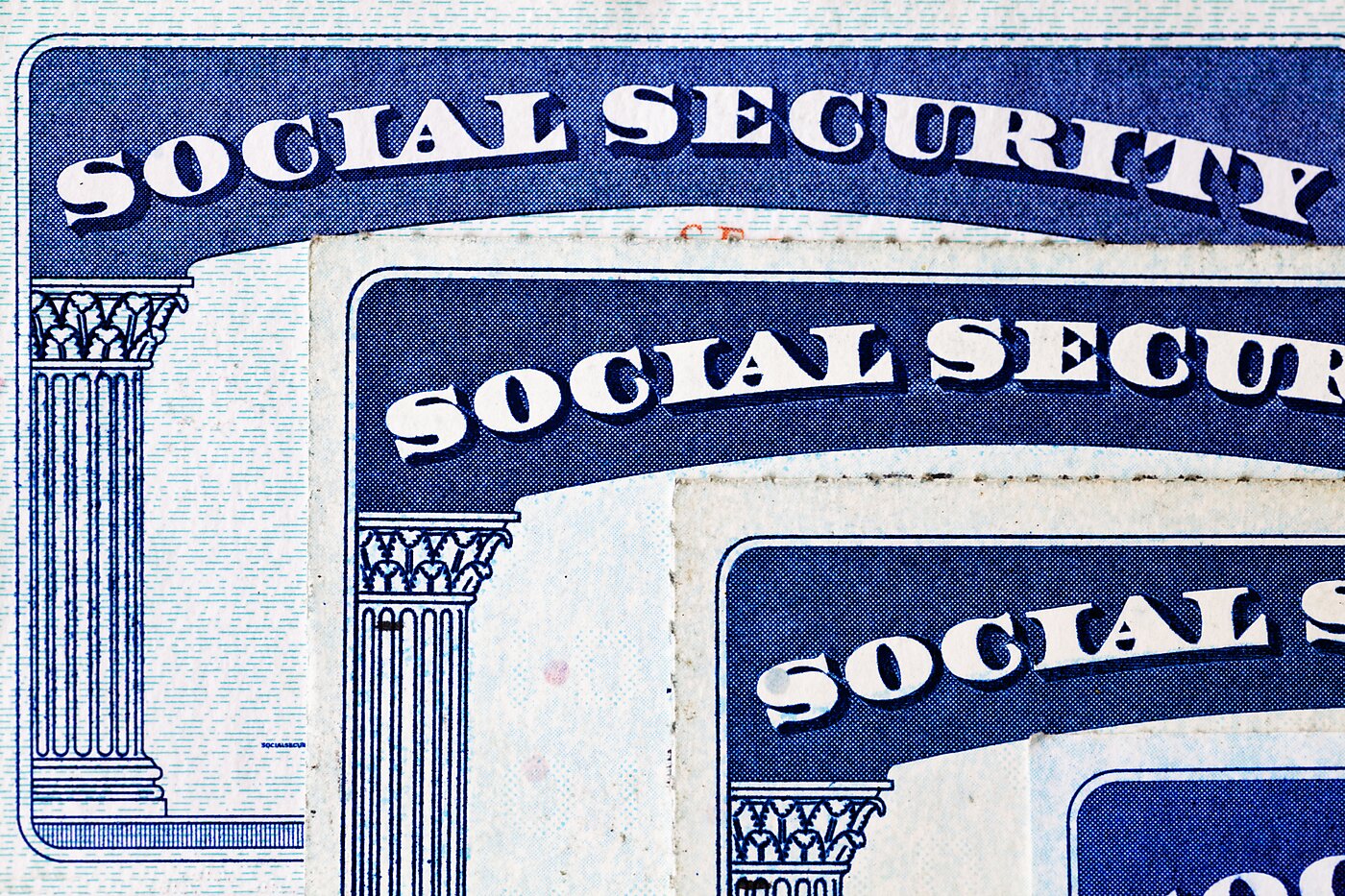 Three Social Security cards stacked